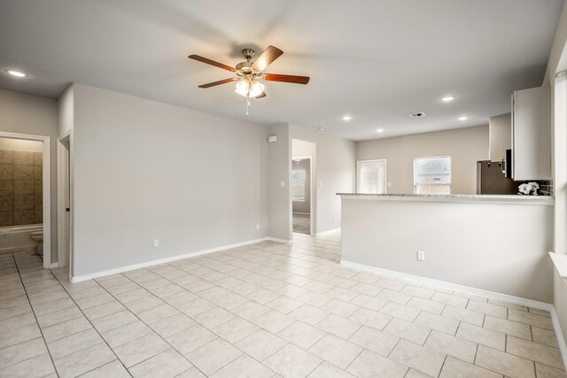 empty room with ceiling fan, baseboards, light tile patterned flooring, and recessed lighting