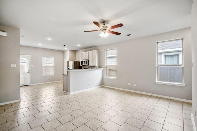 kitchen featuring stainless steel appliances, white cabinetry, visible vents, open floor plan, and ceiling fan