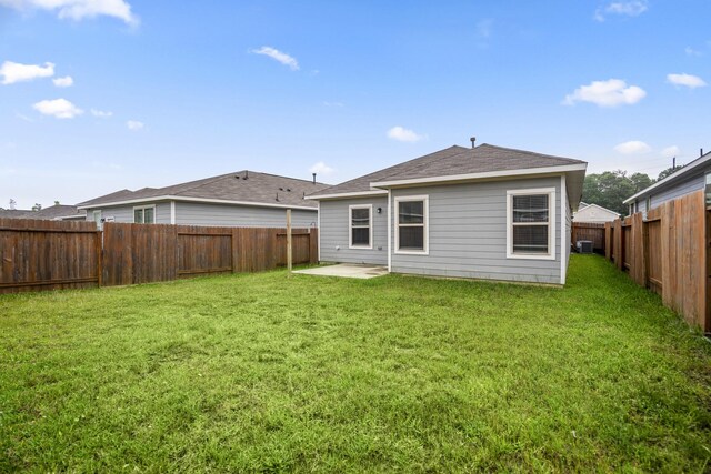 back of house with a patio area, a lawn, a shingled roof, and a fenced backyard