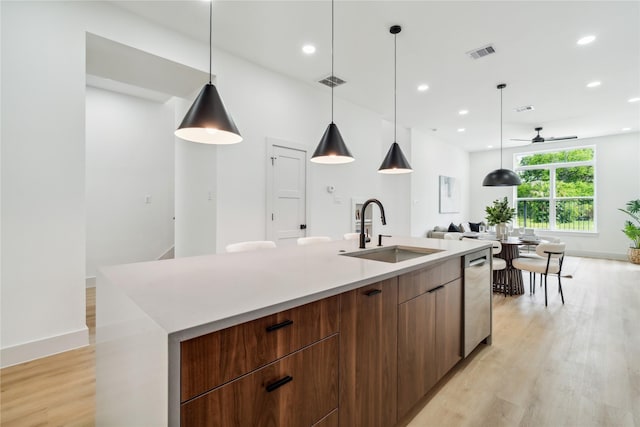 kitchen with a sink, light wood-type flooring, modern cabinets, dishwasher, and visible vents
