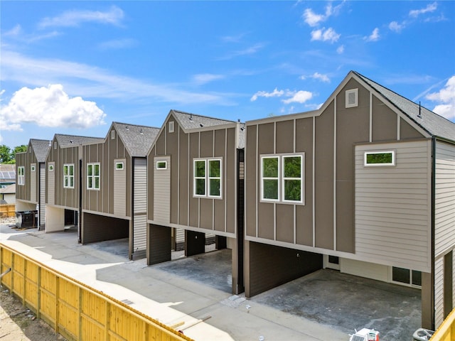 view of property exterior featuring a patio, a residential view, and board and batten siding
