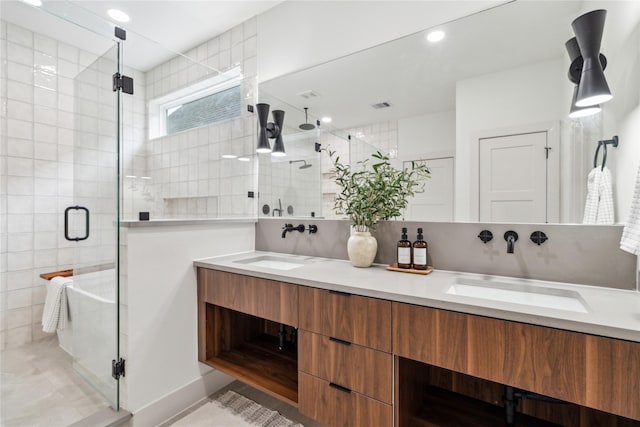 bathroom with double vanity, visible vents, a stall shower, and a sink