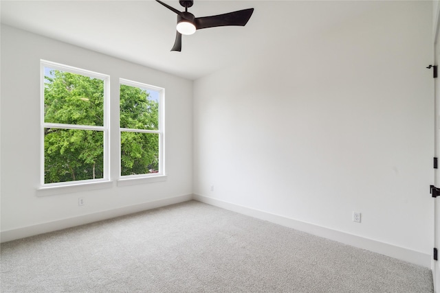 carpeted empty room featuring a ceiling fan and baseboards