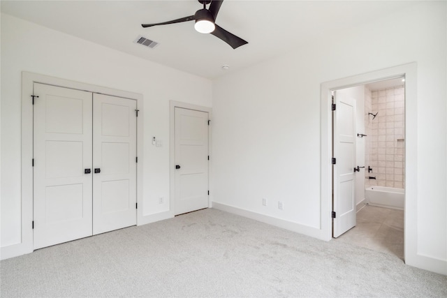 unfurnished bedroom with a ceiling fan, a closet, carpet floors, ensuite bath, and visible vents