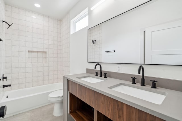 bathroom featuring double vanity, a sink,  shower combination, and toilet