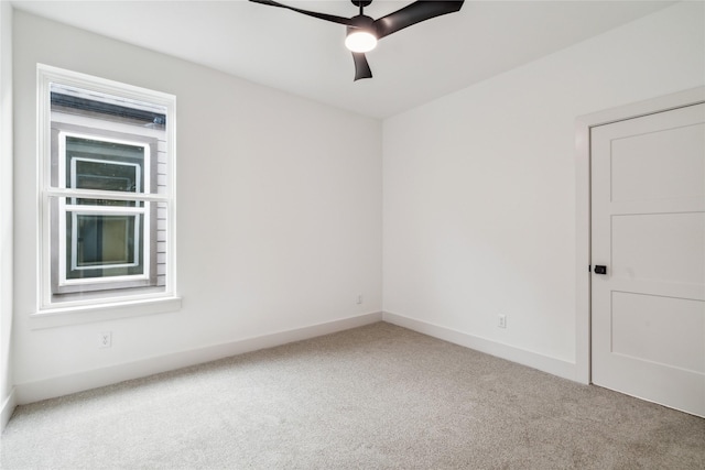 carpeted spare room with baseboards and a ceiling fan