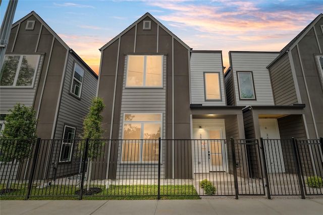 view of front of home featuring stucco siding and a fenced front yard
