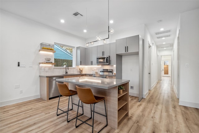 6412 Foster St, Houston, TX 77021 - kitchen featuring visible vents, decorative backsplash, gray cabinetry, open shelves, and appliances with stainless steel finishes