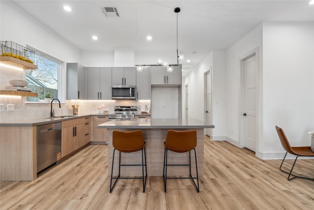 6412 Foster St, Houston, TX 77021 - kitchen featuring stainless steel appliances, light wood-style flooring, a sink, visible vents, and modern cabinets