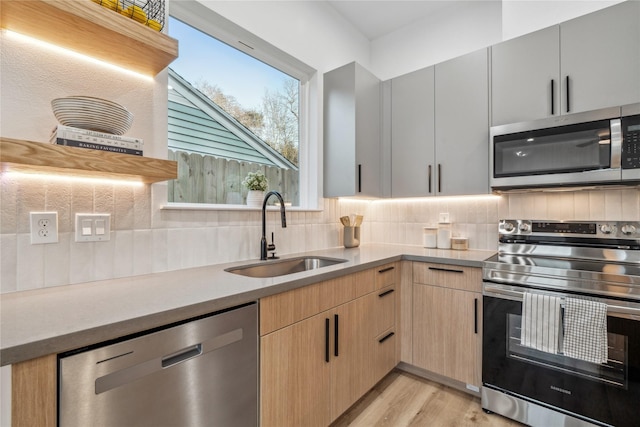 6412 Foster St, Houston, TX 77021 - kitchen featuring backsplash, light wood finished floors, stainless steel appliances, and a sink