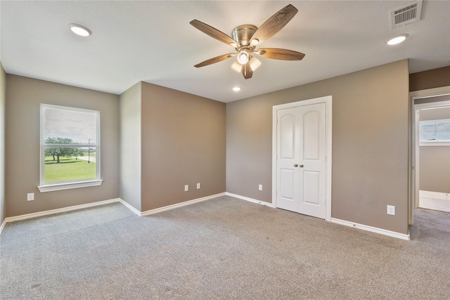 carpeted empty room featuring recessed lighting, visible vents, a ceiling fan, and baseboards
