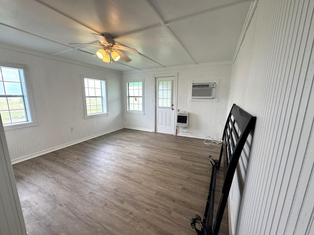 unfurnished living room with crown molding, a wall unit AC, heating unit, and dark wood-style floors