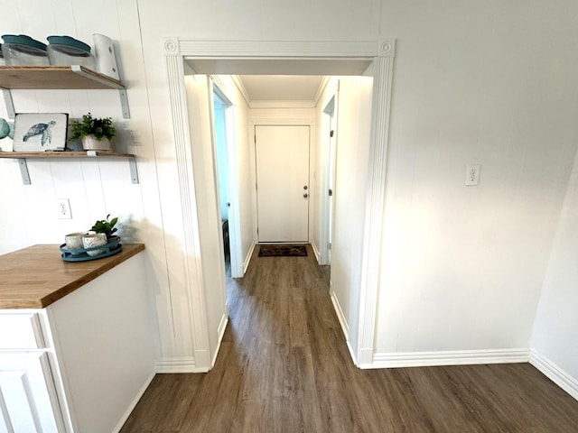 hallway featuring baseboards and dark wood finished floors