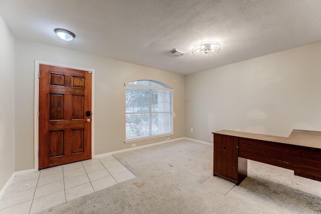 foyer entrance with light carpet, a textured ceiling, visible vents, and baseboards