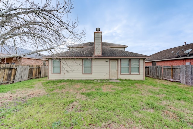 back of property with a lawn, a fenced backyard, and a chimney