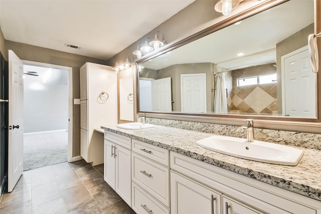 bathroom featuring visible vents, a sink, a shower with shower curtain, and double vanity