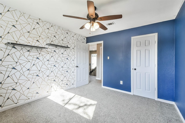 unfurnished bedroom with carpet floors, visible vents, and baseboards