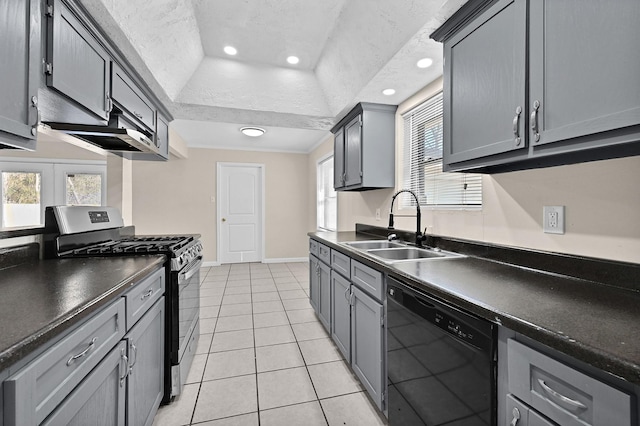 kitchen with dark countertops, dishwasher, light tile patterned floors, a sink, and gas range