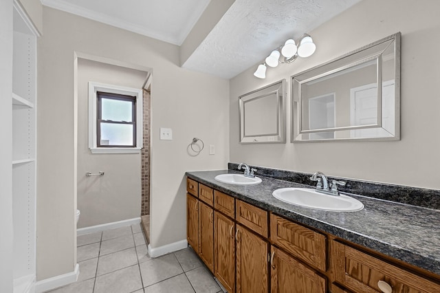 bathroom featuring baseboards, tile patterned floors, a sink, and double vanity