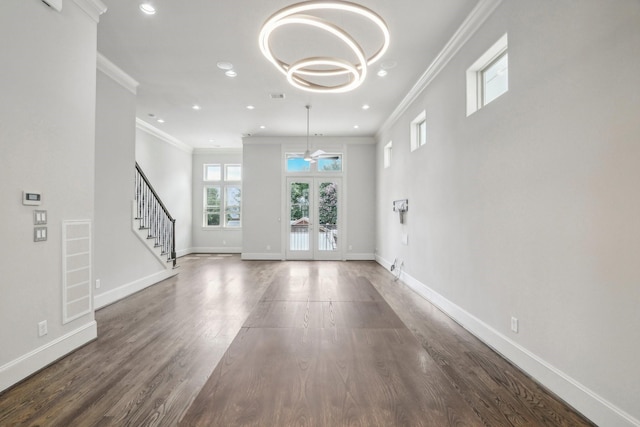 1129 W 21st St, Houston, TX 77008 - unfurnished living room featuring an inviting chandelier, wood finished floors, stairway, baseboards, and ornamental molding