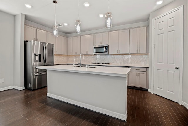 9408 Caddo Ridge Ln, Cypress, TX 77433 - kitchen featuring appliances with stainless steel finishes, light countertops, backsplash, a center island with sink, and recessed lighting