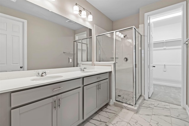 full bath featuring a sink, marble finish floor, and a stall shower
