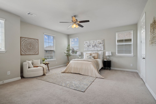 bedroom featuring light colored carpet, baseboards, visible vents, and ceiling fan