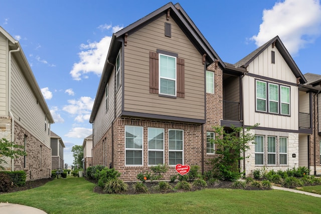 view of front of house with board and batten siding, brick siding, and a front yard
