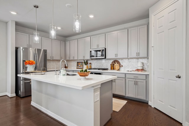 kitchen featuring a sink, gray cabinetry, backsplash, and stainless steel appliances