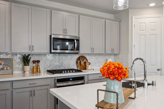 9408 Caddo Ridge Ln, Cypress, TX 77433 - kitchen featuring gray cabinets, appliances with stainless steel finishes, and backsplash