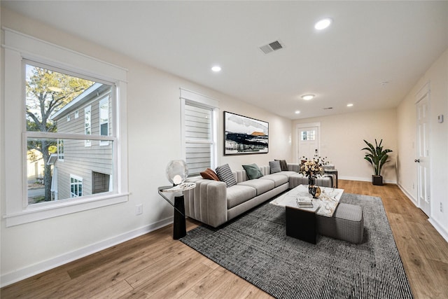 living room featuring baseboards, light wood-style floors, and recessed lighting
