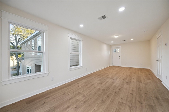 spare room featuring recessed lighting, light wood-style flooring, and baseboards