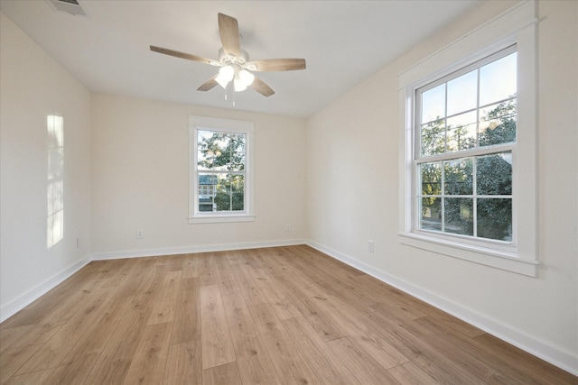 unfurnished room featuring light wood-type flooring, visible vents, baseboards, and ceiling fan