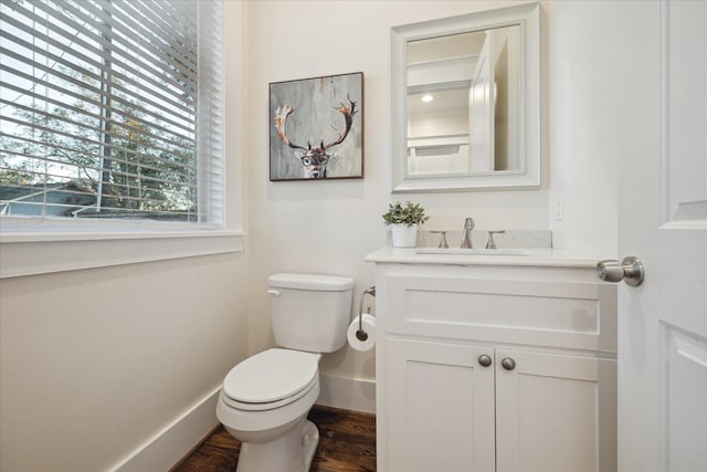 bathroom featuring wood finished floors, vanity, toilet, and baseboards