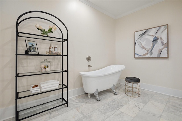 bathroom with a freestanding bath, baseboards, ornamental molding, and marble finish floor