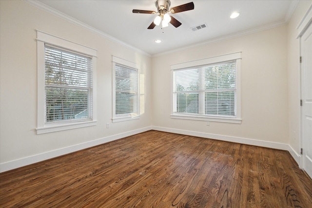 empty room with dark wood-style floors, baseboards, visible vents, a ceiling fan, and crown molding