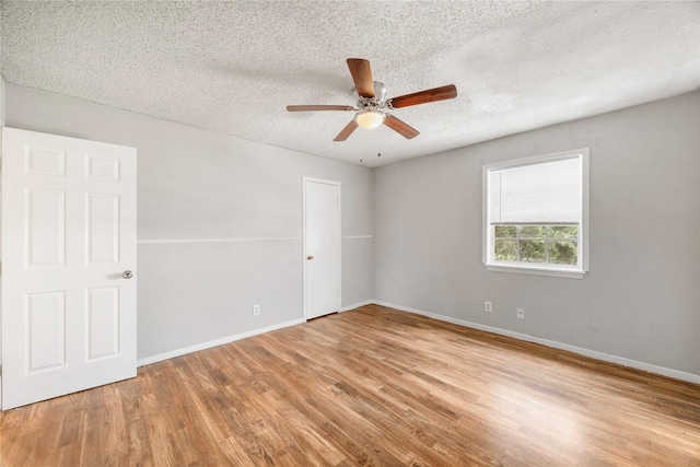 6231 Westward St Unit 20, Houston, TX 77081 - spare room featuring a textured ceiling, ceiling fan, wood finished floors, and baseboards