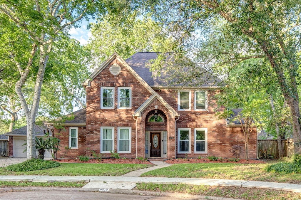 6619 Berrytree Ln, Sugar Land, TX 77479 - view of front of property with brick siding, fence, a shingled roof, and a front yard