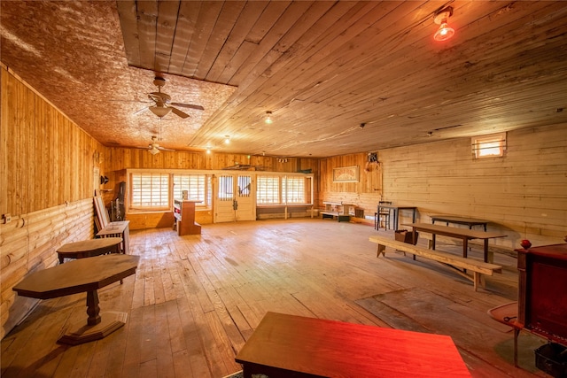 interior space featuring wood walls, ceiling fan, wood-type flooring, and wood ceiling