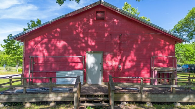 back of house with a deck, a barn, and an outdoor structure
