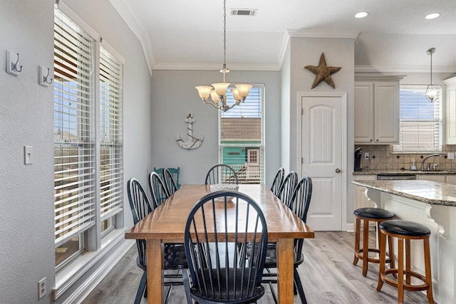 dining room with a chandelier, plenty of natural light, visible vents, and light wood-style flooring