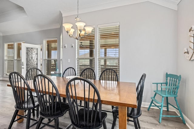 dining room featuring a notable chandelier, a wealth of natural light, baseboards, and ornamental molding