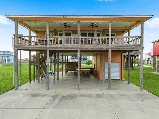 back of property featuring a carport, ceiling fan, a lawn, and driveway