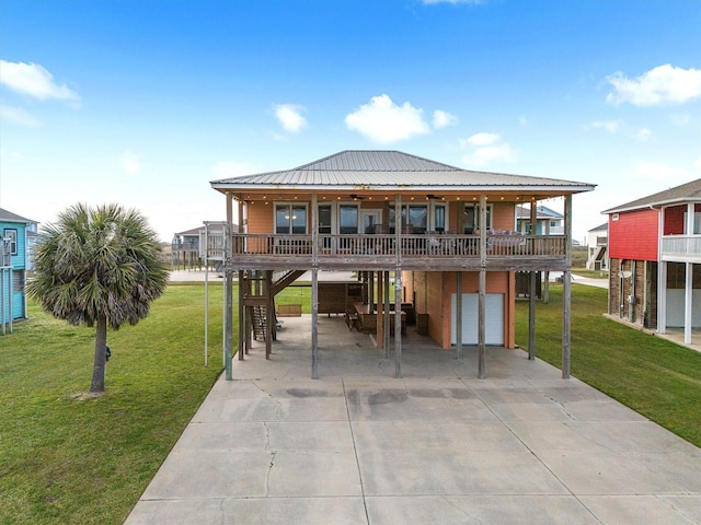 back of house featuring a garage, a lawn, stairway, and concrete driveway