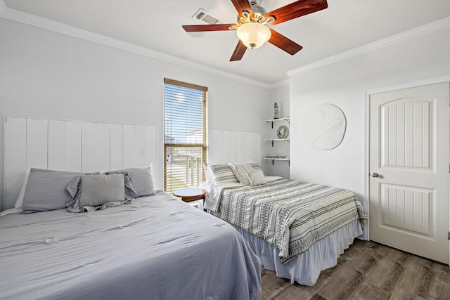bedroom featuring ceiling fan, wood finished floors, visible vents, and ornamental molding