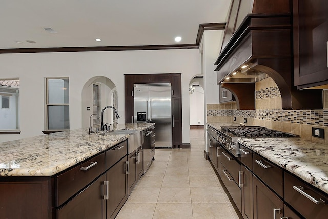 kitchen featuring arched walkways, stainless steel appliances, tasteful backsplash, visible vents, and ornamental molding