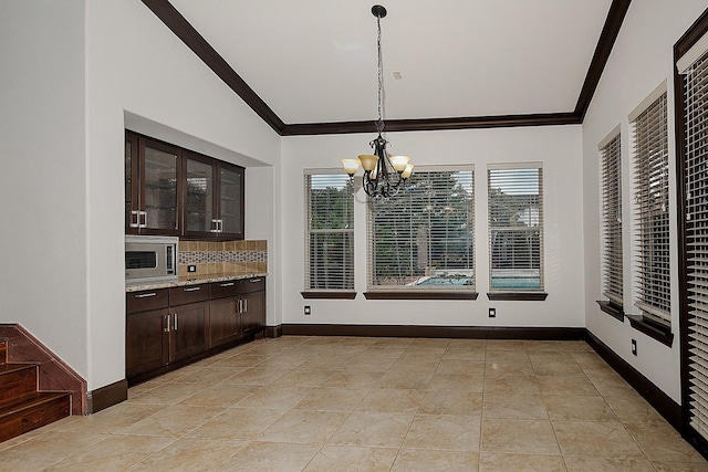 unfurnished dining area with light tile patterned floors, ornamental molding, lofted ceiling, and a chandelier