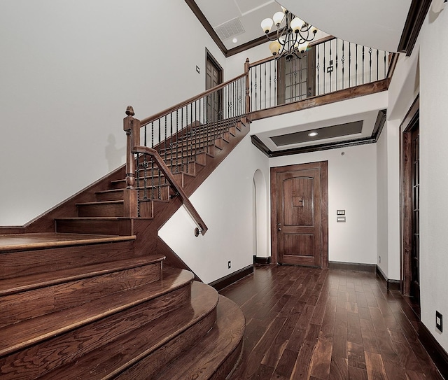 stairs featuring baseboards, ornamental molding, arched walkways, and a notable chandelier