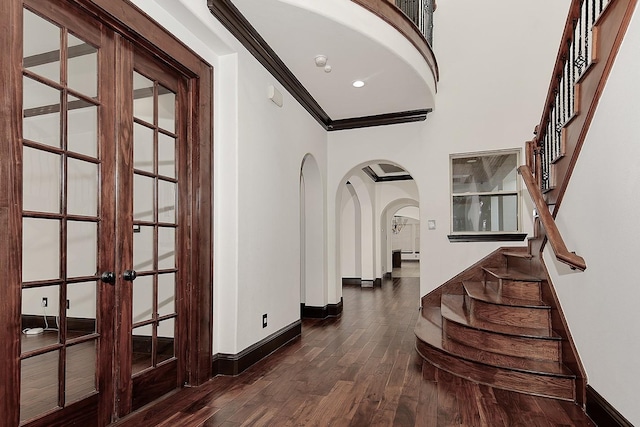 entryway with baseboards, dark wood-style floors, stairway, french doors, and arched walkways