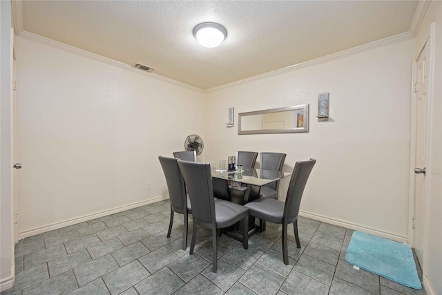 dining room with baseboards, visible vents, ornamental molding, and a textured ceiling